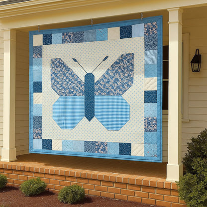 The Butterfly Quilt Downloadable PDF Quilt Pattern, featuring a blue butterfly design and patchwork border, is displayed on the porch of a white house with brick steps.
