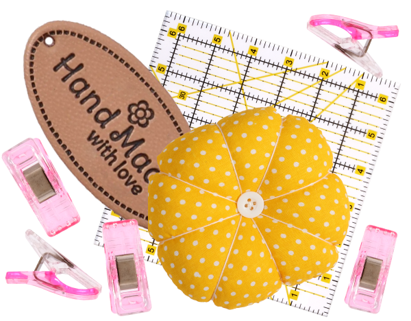 The 8 Free Digital Pattern Bundle is displayed alongside sewing accessories—including a yellow polka dot pincushion, sewing label, pink clips, and a clear quilting ruler—arranged on a white background.