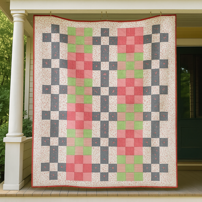 Grandma's Picnic Quilt, featuring a cozy patchwork pattern in pink, green, gray, and cream, hangs on a porch in front of a doorway. Download the PDF quilt pattern for your next project.
